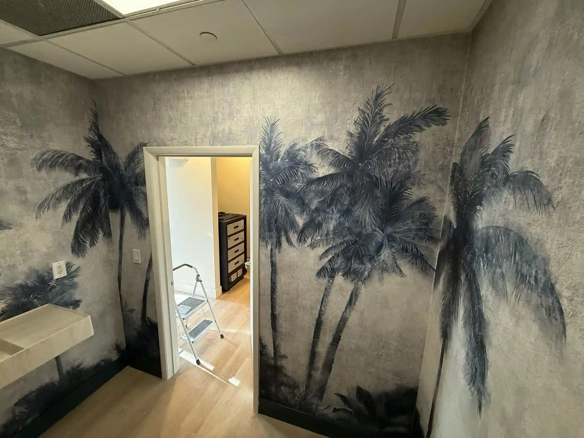 Professional wallpaper installer applying wall covering in Los Angeles home